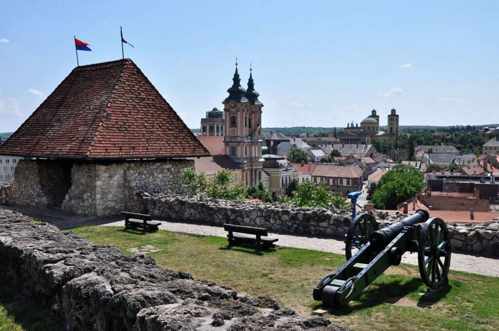 Старая артиллерийская пушка и лавочки на стене древней крепости.