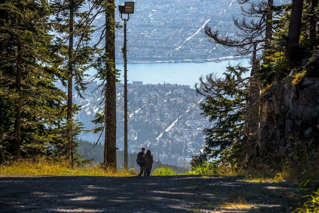 Молодой человек и девушка спускаются с большой горы в Ванкувере.