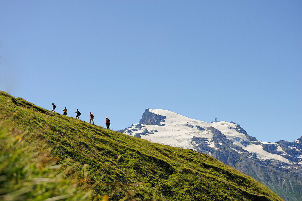 Пять человек поднимаются по склону гору.