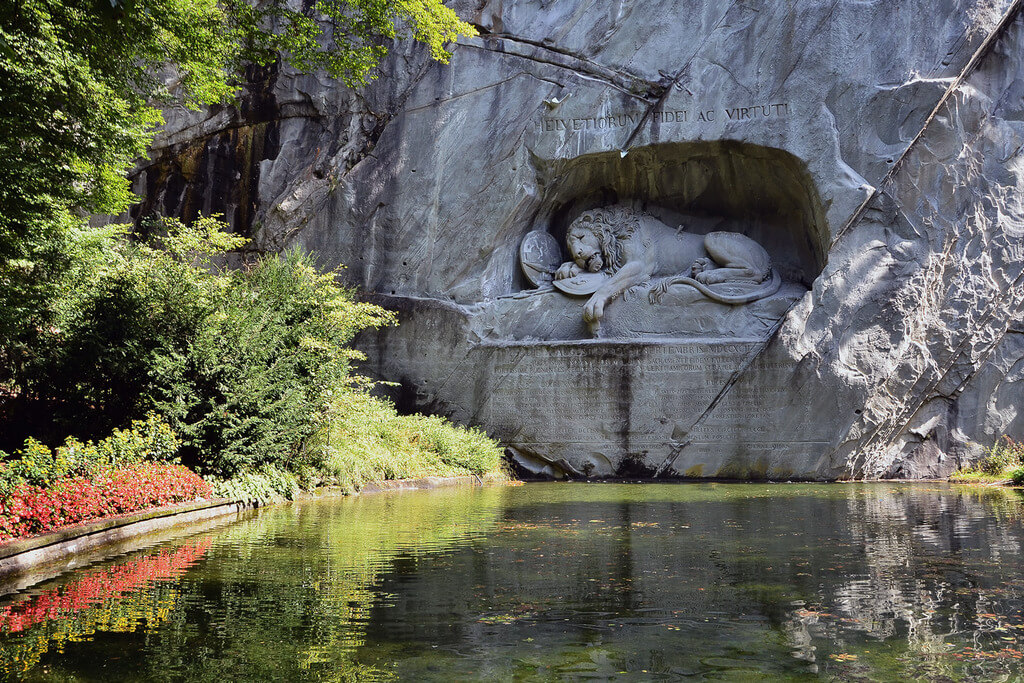 Фигура лежащего льва, высеченная в скале.