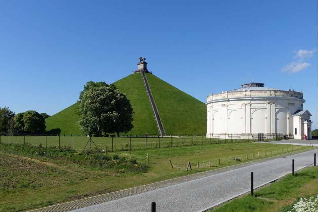 Вид на музей-панораму и зеленый высокий холм со статуей льва на вершине.