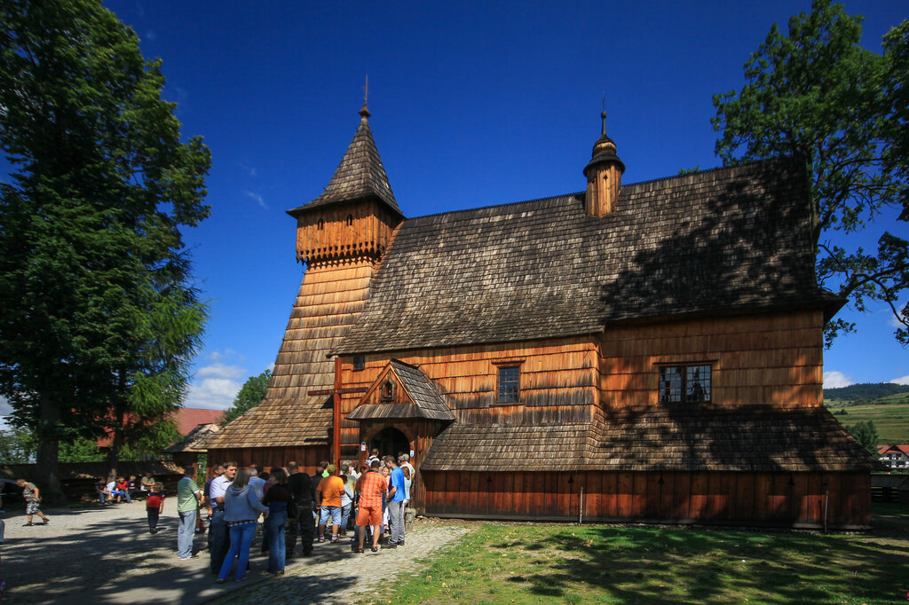 Очередь из туристов в старинную деревянную церковь.