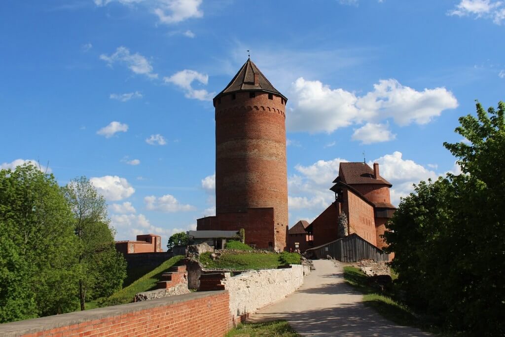 Турайдский замок, строения из красного кирпича, большая круглая башня.