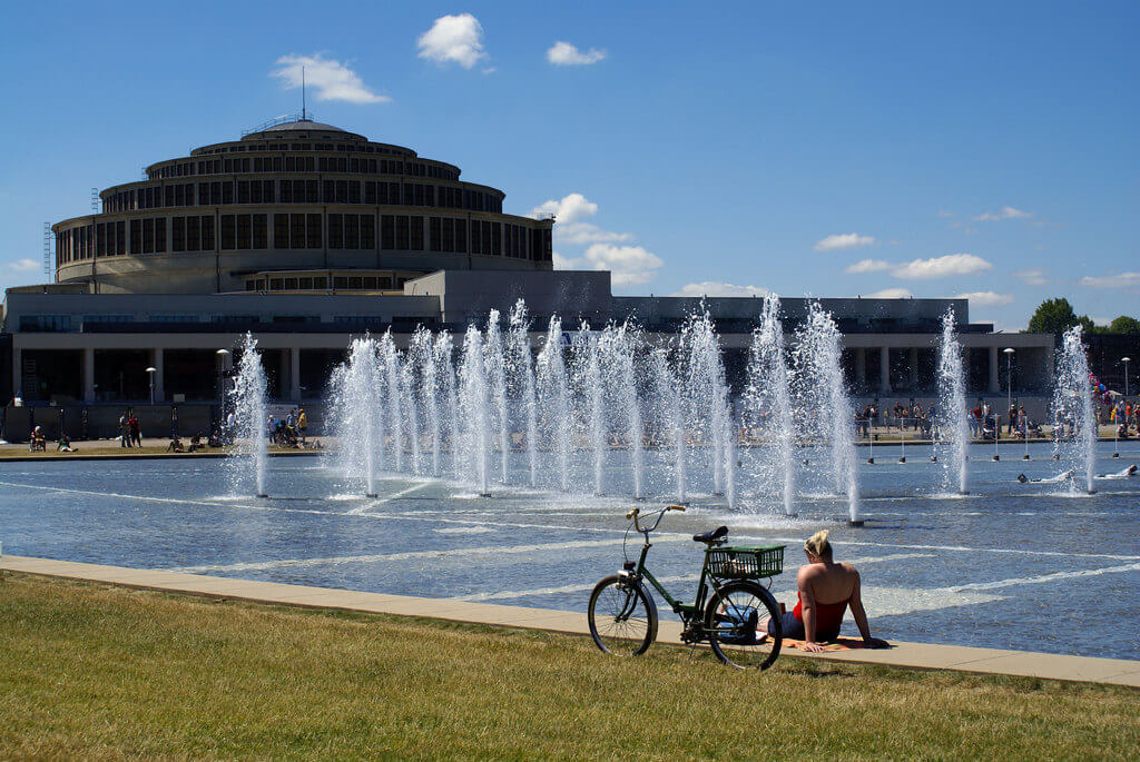Девушка с велосипедом отдыхает у Вроцлавского фонтана.